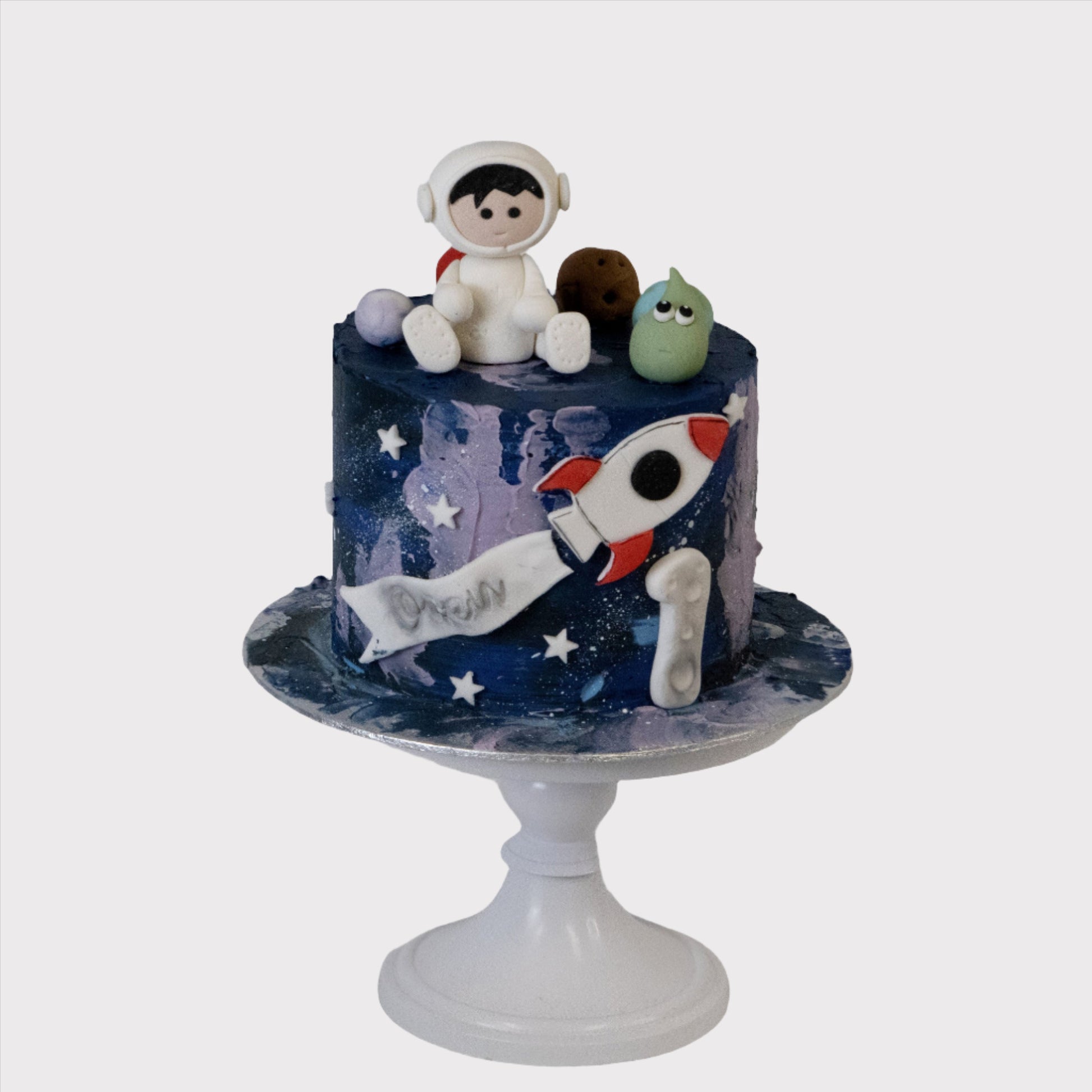 Galaxy kindertaart met astronaut figuur en raket, gepersonaliseerd met naam en leeftijd
