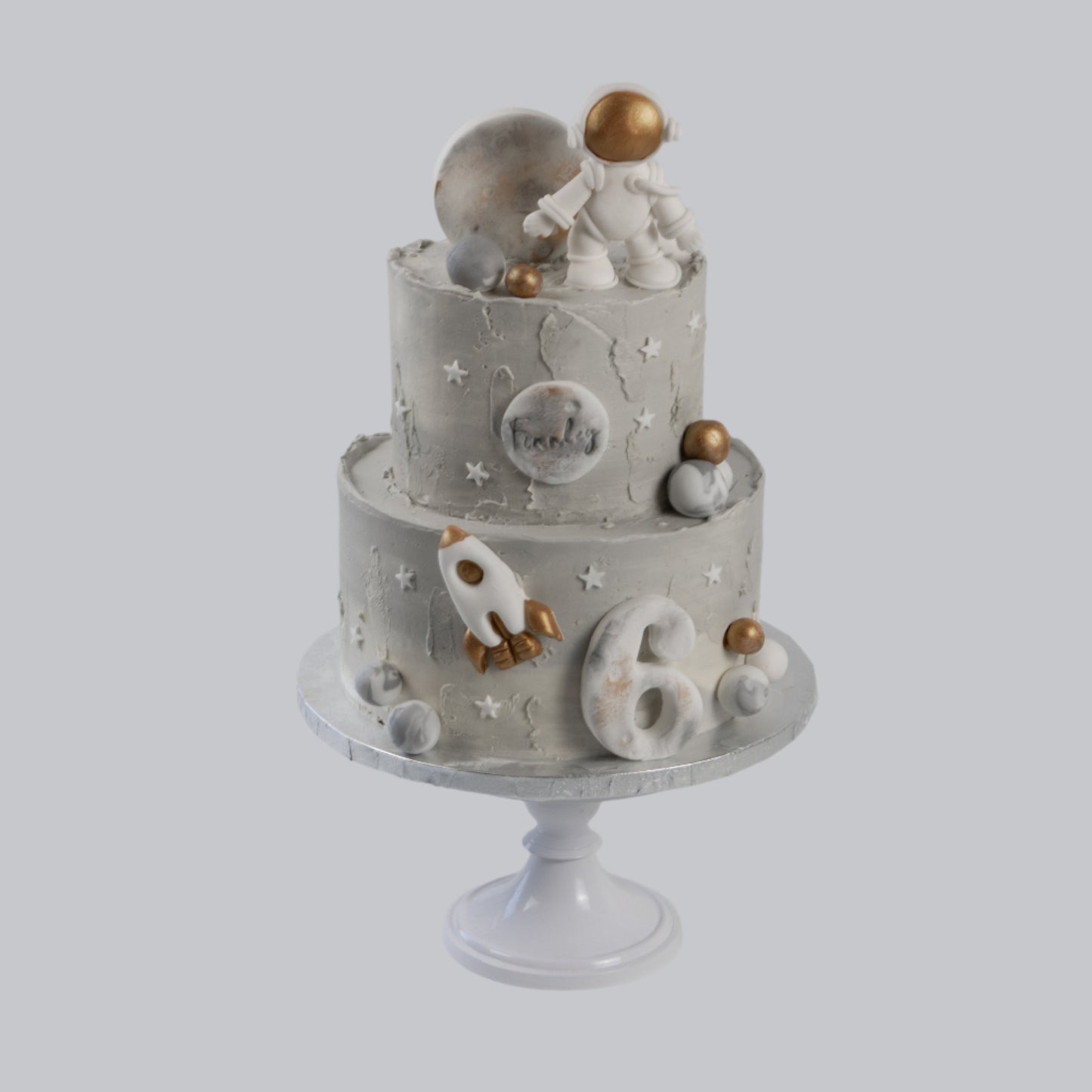 Twee lagen galaxy kindertaart met astronaut, raket en sterrenstelsel ontwerp
