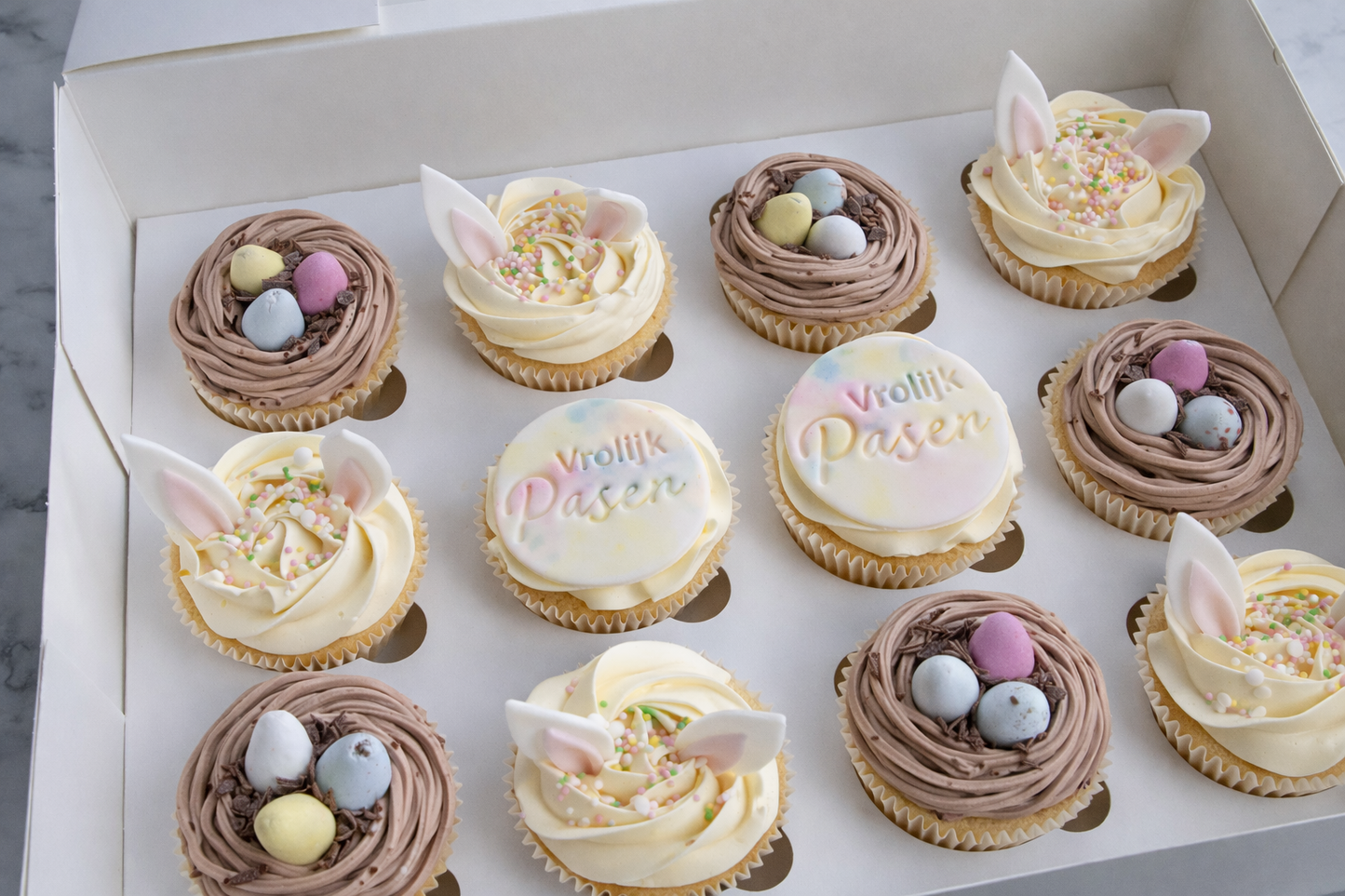 Paas cupcake box met konijnenoren, chocolade nestjes en Vrolijk Pasen cupcakes – feestelijke paas cupcakes bezorgd in Zeist en regio Utrecht.